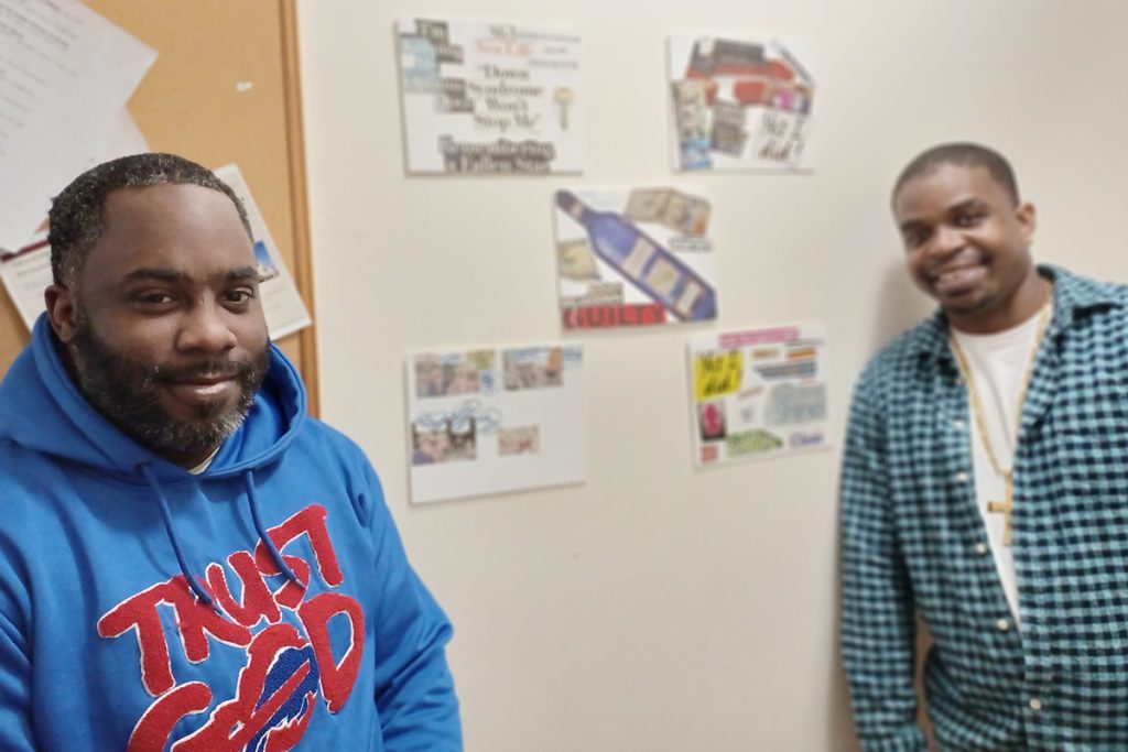 Unity House residents Brion and Kennon in front of recovery collages